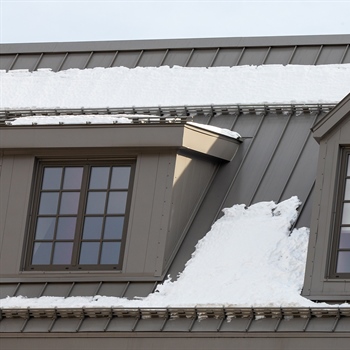 Pre-assembled AceClamp metal roof snow guards safeguarding Delmar Hotel and its guests from snow hazards.