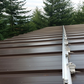 Patented non-penetrating push-pin design for metal roof snow rails