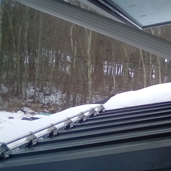 AceClamp snow bars securing heavy snow loads on a residential roof.